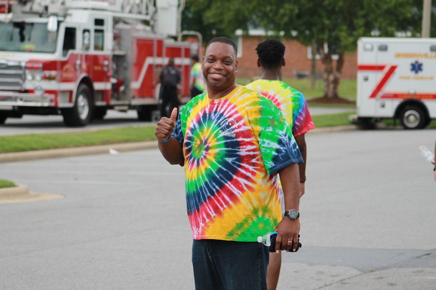 A smiling DAFF volunteer wearing a colorful tie-dye shirt